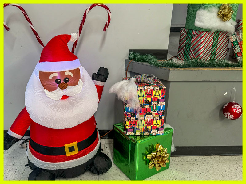 Santa and gifts in front of large candy canes